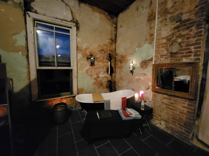 Original listing photo of the Champion House bath and exposed brick fireplace wall