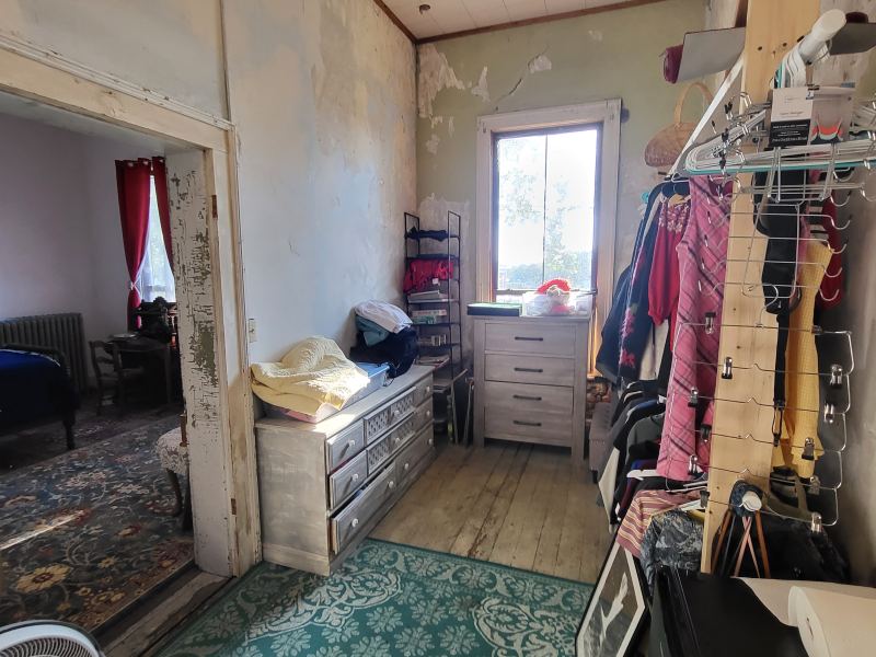 Original listing photo of a Champion House bedroom with blue bed and red curtains