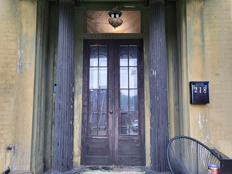 Original listing photo of the Champion House front entry door and columns