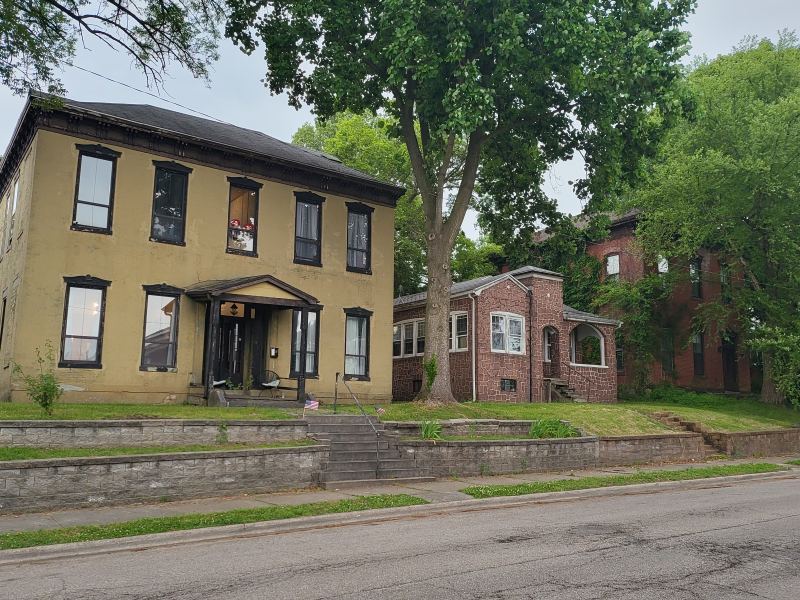 Original listing photo of Champion House front facade and yard